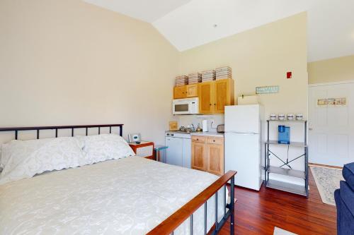 a bedroom with a bed and a kitchen with a refrigerator at Bethany Beach Inn - 39634 Jefferson Bridge Rd #201 in Bethany Beach