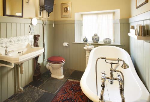 a bathroom with a tub and a sink and a toilet at Toll House in Nether Stowey