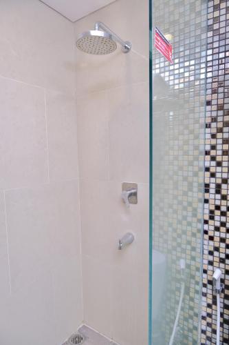a shower with a glass door with an american flag at @Hom Semarang Simpang Lima in Semarang