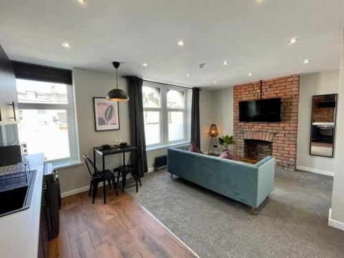 a living room with a blue couch and a fireplace at Stylish central apartment for 2 people free parking in Cardiff