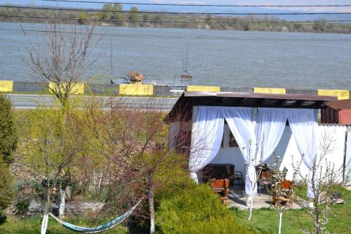 a tent with a white curtain in front of a body of water at Cabana Timeea in Ostrovu Corbului