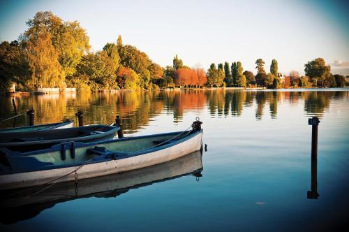 two boats are docked on a lake with trees at Ô Cottage - Maison d'hôtes proche Paris à 20 minutes in Deuil-la-Barre