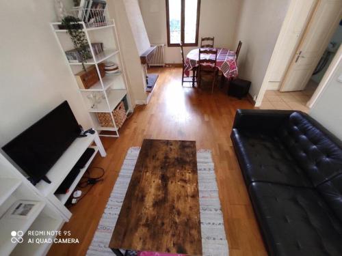 Ô Cottage La Barre Ormesson - 20 min Paris في Deuil-la-Barre: غرفة معيشة مع أريكة وطاولة قهوة