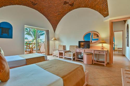 a hotel room with two beds and a balcony at Dream Lagoon Resort & Aqua Park in Marsa Alam City