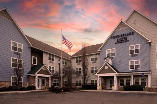 a hotel with an american flag in front of it at TownePlace Suites Medford in Medford