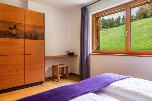 ein Schlafzimmer mit einem Bett und einem großen Fenster in der Unterkunft Haus Tirol Apt Lausgitsch in Lajen