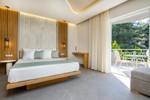 een slaapkamer met een bed en een balkon bij Green Bay in Limenaria