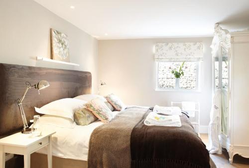 a bedroom with a bed and a lamp and a window at Brooks Lodge Sussex in Tarring Neville