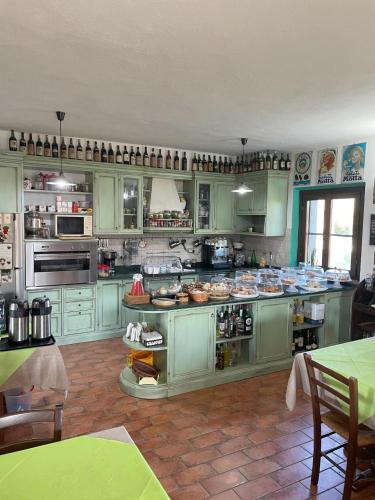 a large kitchen with green cabinets and appliances at Locanda le Mandriane in Orbetello