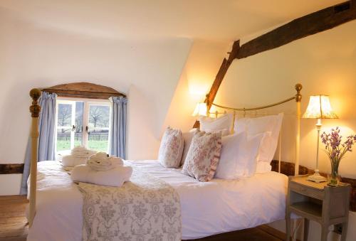 a bedroom with a bed with white sheets and pillows at Field Cottage in Little Comberton