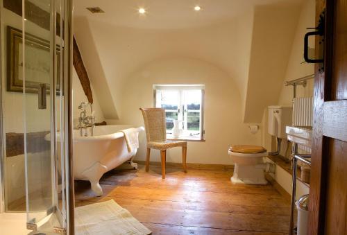 a bathroom with a tub and a toilet and a sink at Field Cottage in Little Comberton