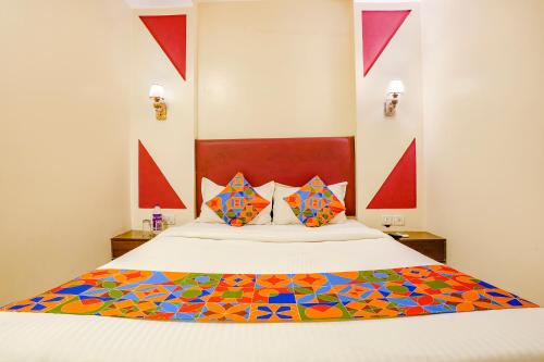 a bedroom with a large bed with colorful pillows at FabHotel D69 Residency in Mire