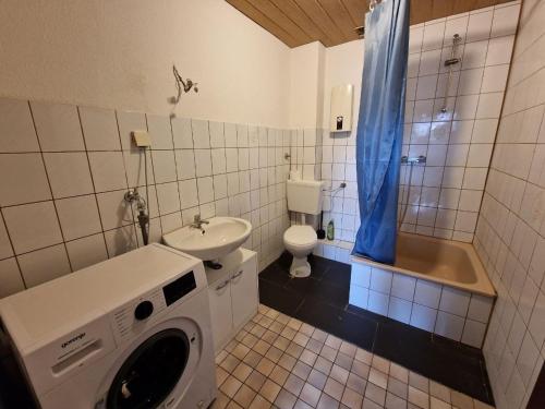 a washing machine in a bathroom with a sink and a toilet at K&K Unterkunft GbR, Wohunung 3 in Duisburg