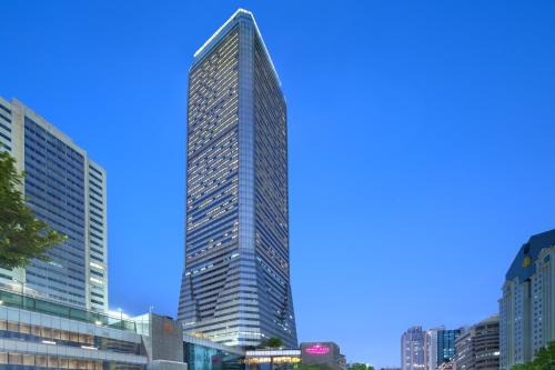 a tall building in a city with a blue sky at Crowne Plaza Guangzhou City Centre, an IHG Hotel - Free Canton Fair Shuttle Bus and Registration Counter in Guangzhou