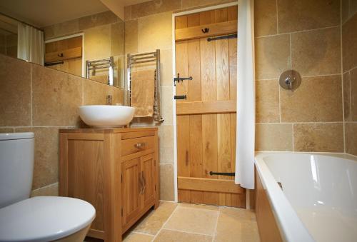 uma casa de banho com um lavatório, um WC e uma banheira em Rampisham Hill Farm Barn em Hooke