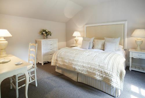 une chambre avec un lit, une table et un bureau dans l'établissement Mews Cottage, à Helston