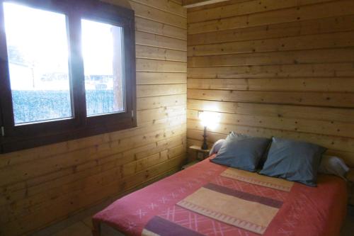 a bedroom with a bed in a wooden room at Chalet écologique en campagne bazadaise in Saint-Côme