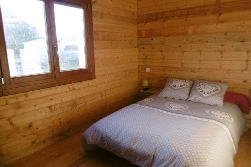 a bedroom with a bed in a log cabin at Chalet écologique en campagne bazadaise in Saint-Côme