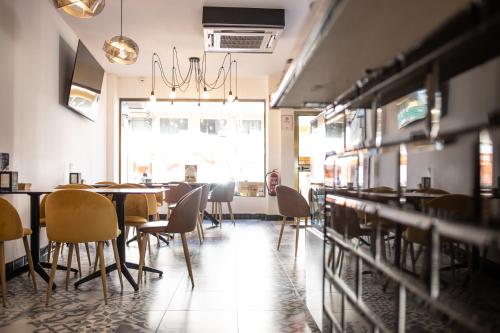 un restaurante con mesas y sillas y una persona sentada en una mesa en Hotel Agur, en Fuengirola