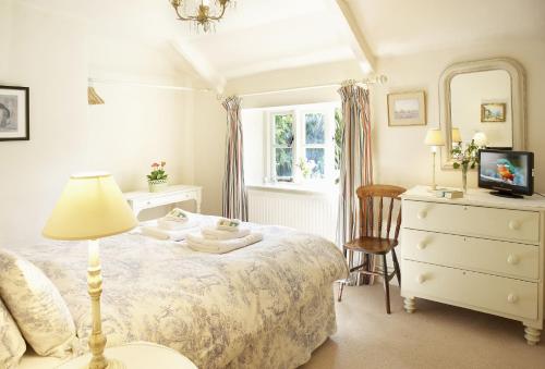 a bedroom with a bed and a dresser and a mirror at Pear Tree Cottage Norfolk in Little Barningham