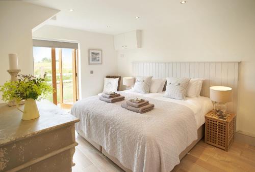 a bedroom with a large bed with towels on it at Furlong Barn in Southam