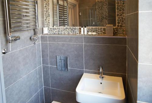 a bathroom with a sink and a mirror at Furlong Barn in Southam