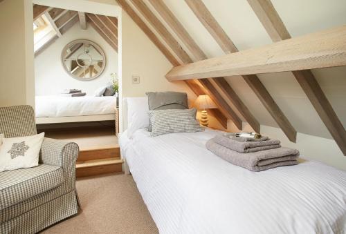 a bedroom with a white bed and a mirror at Furlong Barn in Southam