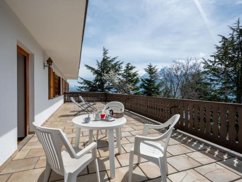 eine Terrasse mit einem Tisch und Stühlen auf dem Balkon in der Unterkunft Apartment Aigle by Interhome in Sarre