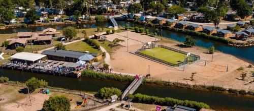 a park with a tennis court in the middle of a river at Mobil home camping 4 étoiles les Viviers 2 chambres in Lège-Cap-Ferret