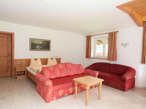 a living room with a red couch and a table at Apartment Monika-1 by Interhome in Gattererberg