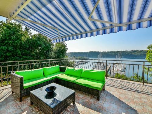 a patio with a green couch and a table at Apartment Marija by Interhome in Omišalj