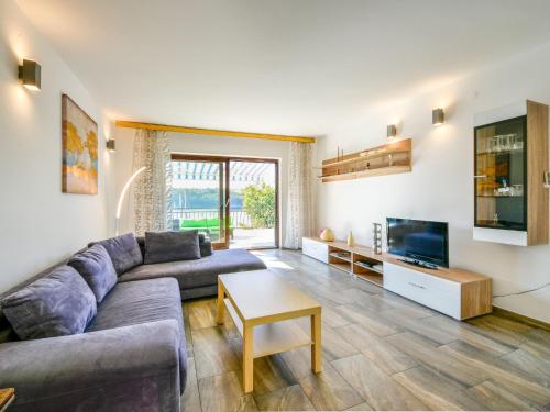 a living room with a couch and a tv at Apartment Marija-1 by Interhome in Omišalj
