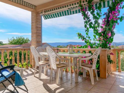 eine Terrasse mit Tisch und Stühlen auf einem Deck in der Unterkunft Apartment Andjelka by Interhome in Malinska