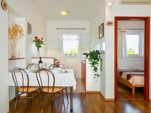 eine Küche und ein Esszimmer mit Tisch und Stühlen in der Unterkunft Apartment Andjelka by Interhome in Malinska