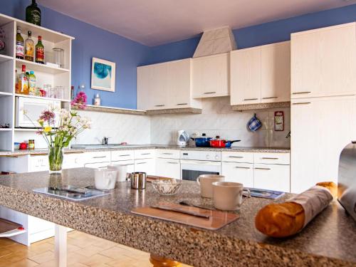 une cuisine avec des placards blancs et un grand îlot dans l'établissement Holiday Home Les Velours by Interhome, à Tavernes