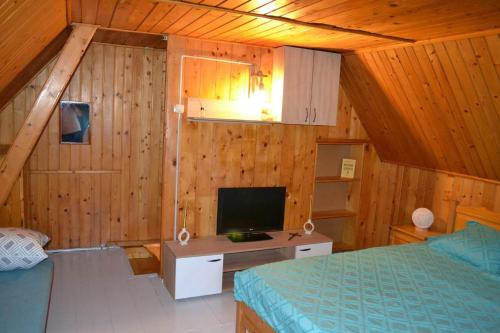 - une chambre avec un lit et une télévision dans une cabine dans l'établissement Cabana Timeea, à Ostrovu Corbului