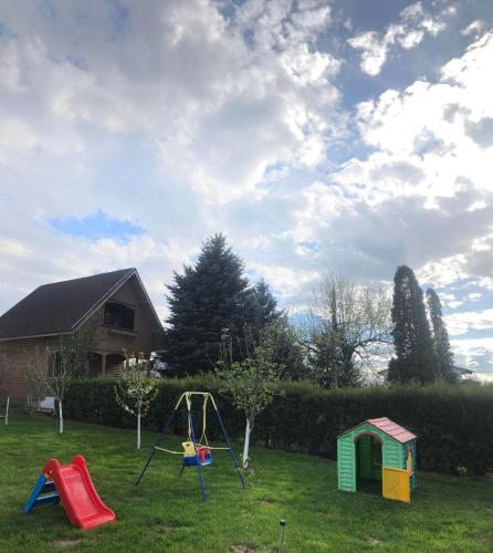 a yard with a playground and a house at Cabana Timeea in Ostrovu Corbului