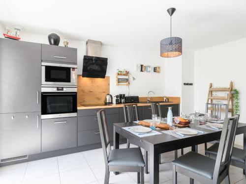 a kitchen with a table with chairs and a dining room at Apartment Les Patios de Flore-1 by Interhome in Mimizan-Plage