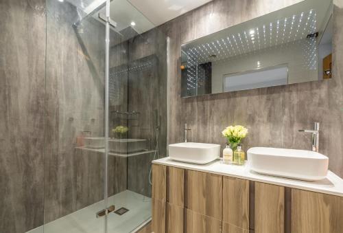 a bathroom with two sinks and a shower at Thatch Barn in Lingwood