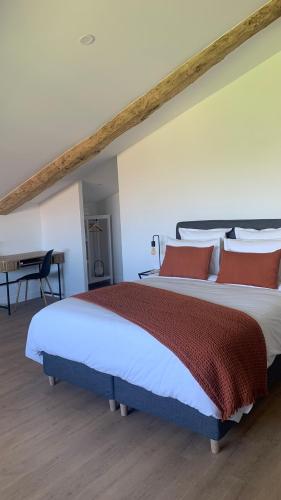 une chambre avec un grand lit avec des oreillers rouges dans l'établissement Maison Divon, à Montagne
