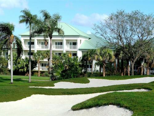 uma casa branca com palmeiras em frente a um campo de golfe em Apartment Provident Doral at The Blue-7 by Interhome em Miami