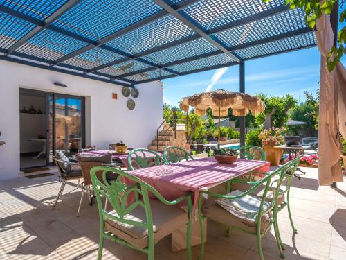 un patio con mesa y sillas bajo una pérgola en Holiday Home Can Rochet by Interhome, en Alaró