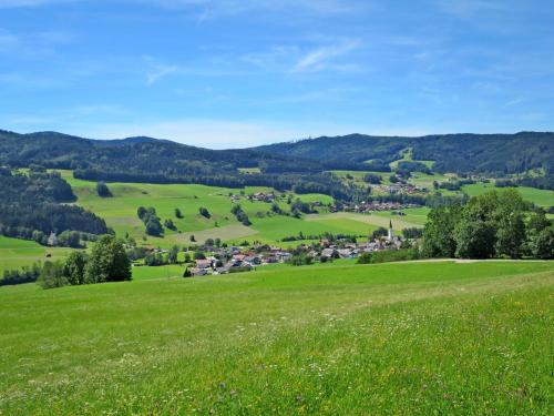 a green hillside with a village in the distance at Apartment Waldfrieden by Interhome in Oberwang