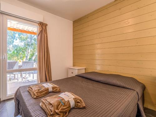 une chambre avec deux lits et une fenêtre dans l'établissement Apartment Residence Marina di Favone- T2- 2-4 pers-3 by Interhome, à Conca