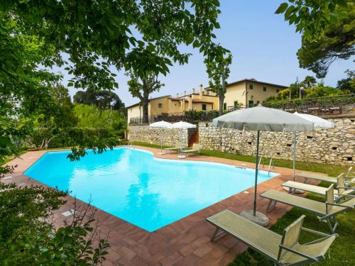 een zwembad met 2 stoelen en een parasol bij Holiday Home Villa La Guardia Vecchia-1 by Interhome in Crespina