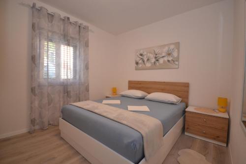 a small bedroom with a bed and a window at Sun kiis in Postira