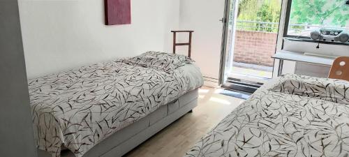 a bedroom with two beds and a window at Woning dicht bij strand en stad in Hoorn