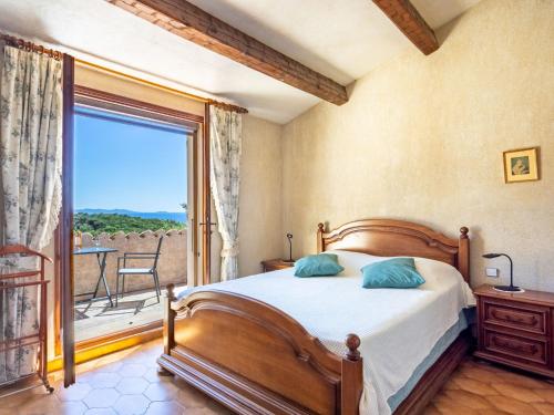 une chambre avec un lit et une grande fenêtre dans l'établissement Villa Maison de l'Hubac Bleu by Interhome, au Lavandou