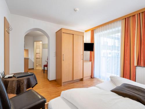 a hotel room with a bed and a chair at Apartment Rosa-9 by Interhome in Mayrhofen