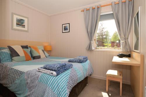 a bedroom with two beds and a window at Blairlagan Lodge in Hunters Quay